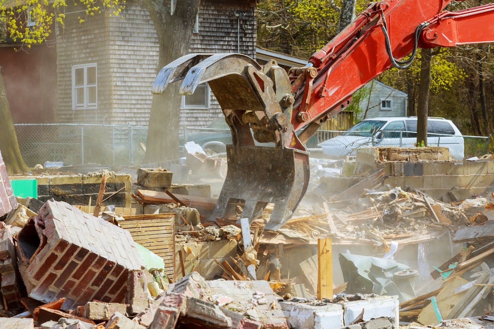 An old house is knocked down by heavy machinery during demolition services.