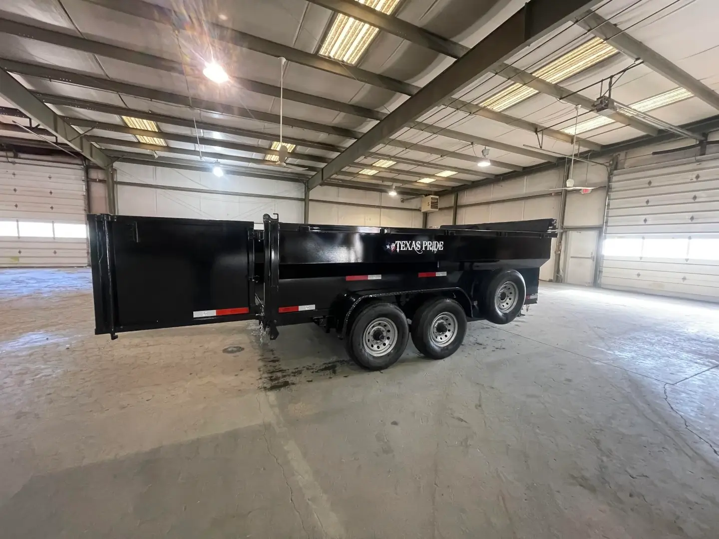 A large dumpster rental provided by MALC Rentals in a warehouse.