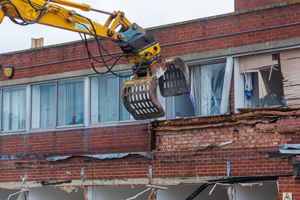 An old brick building is destroyed by professional demolition services.