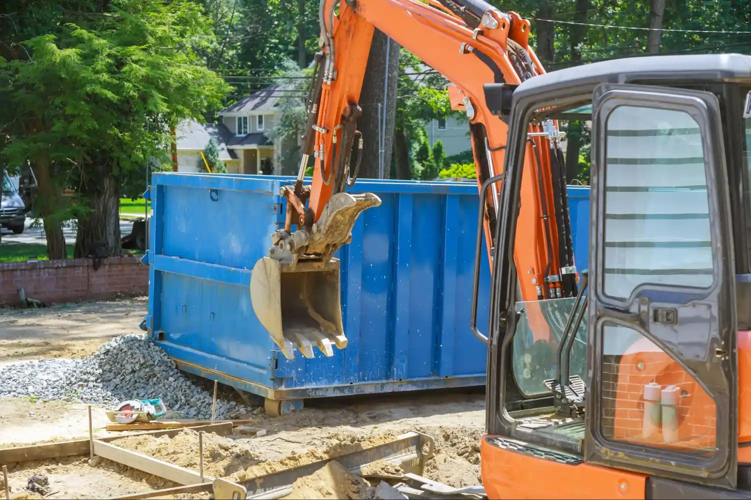 Blue dumpster in front of a construction crane.